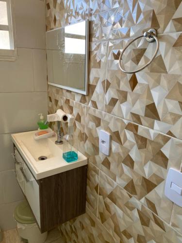 a bathroom with a sink and a mirror at Kitnet Centro da Cidade in São Bento do Sapucaí