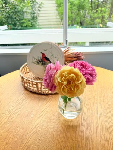 un vase de fleurs assis sur une table dans l'établissement Renovated Entire 2BR Flat, Comfort, Scenic Views, Free Parking & 10 min to Ferry, à Wellington