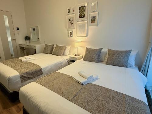two beds in a room with two bedsitures at OUCHI HOTEL Hiroshima Station in Hiroshima