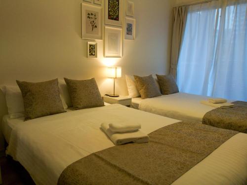 a bedroom with two beds with towels on them at OUCHI HOTEL Hiroshima Station in Hiroshima