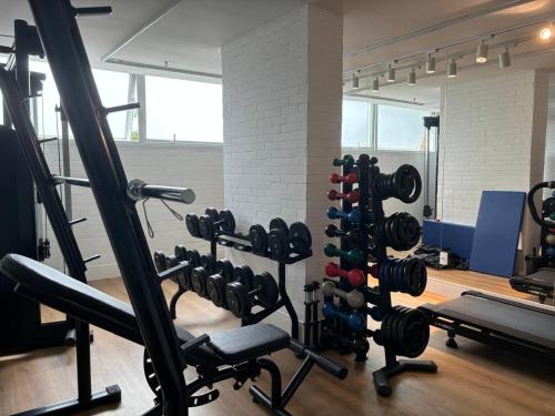 a gym with a bunch of weights at Linhares Design Hotel LC 202 in Linhares