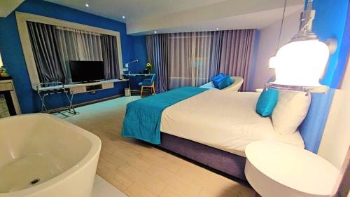 ein Hotelzimmer mit Bett und Badewanne in der Unterkunft Bhanwar Pattaya Park Hotel in Pattaya South