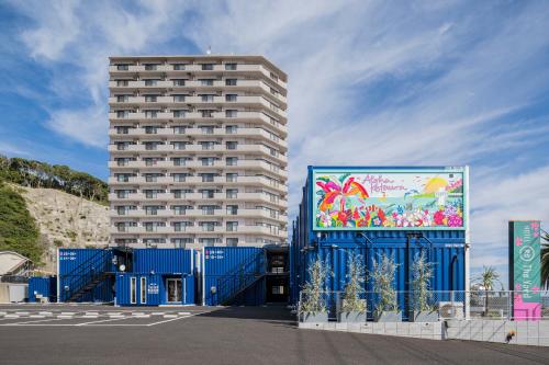 a tall building with a mural on the side of it at HOTEL R9 The Yard Katsura in Katsuura