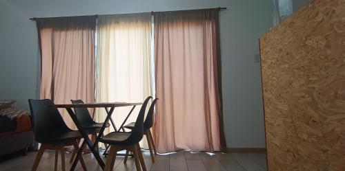 ein Raum mit einem Tisch und Stühlen und einem Fenster in der Unterkunft Corazón de viajero in Mar del Plata