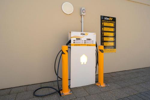 a gas pump with a phone on the wall at Bethlehem Motor Inn and Conference Centre in Tauranga