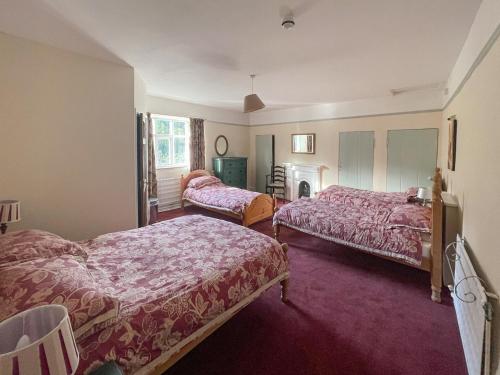 ein Hotelzimmer mit zwei Betten und einem Kamin in der Unterkunft Duvale Priory - 9985 in Bampton