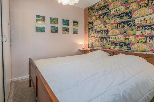 1 dormitorio con 1 cama con un gran mural en la pared en Duinedel 2A-2E, en Oostduinkerke