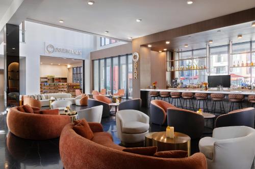 a restaurant with tables and chairs and a bar at Otonomus Hotel Las Vegas in Las Vegas