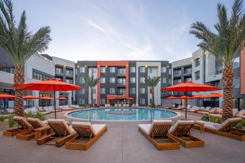 a swimming pool with lounge chairs and umbrellas at Otonomus Hotel Las Vegas in Las Vegas