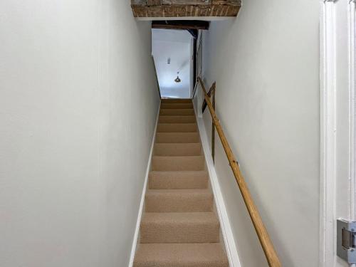 a stairway with white walls and a stair case at The Merchants Penthouse - Uk50408 in Canterbury