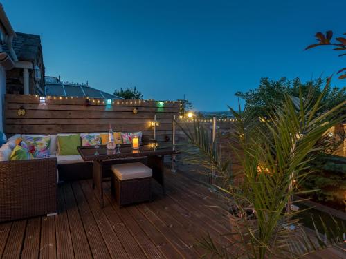 eine Terrasse mit einem Sofa und einem Tisch auf einer Terrasse in der Unterkunft Harpers Cottage in Barrowford