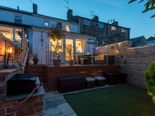 ein Haus mit einem Garten und einer Terrasse in der Unterkunft Harpers Cottage in Barrowford