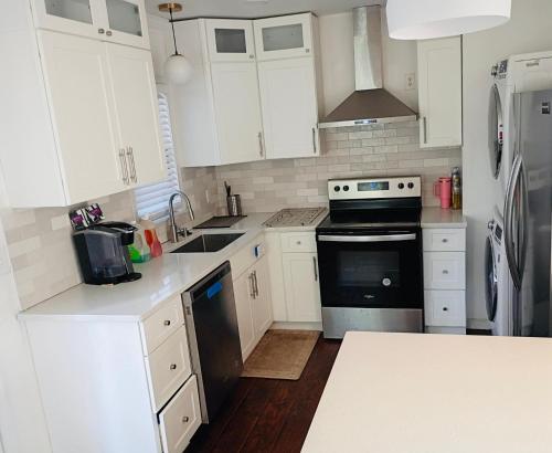 eine Küche mit weißen Schränken und schwarzen Geräten in der Unterkunft Piedmonts Escape in Atlanta