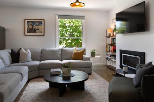 a living room with a couch and a table at Wayward Cottage in Daylesford