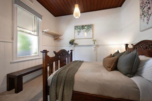 a bedroom with a bed and a window at Wayward Cottage in Daylesford