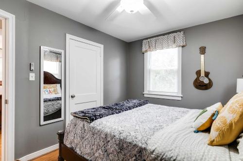 a bedroom with a bed and a guitar on the wall at The Cozy Bungalow 3 parking fully fenced yard in Sweet Briar Park