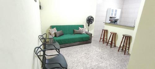 - un salon avec un canapé vert et des tabourets dans l'établissement Casa de praia Região dos Lagos - CASA VERDE - Unamar - Cabo Frio RJ, à Cabo Frio