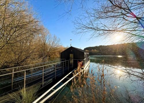 a building on the side of a body of water at St Andrews Lakes in Halling
