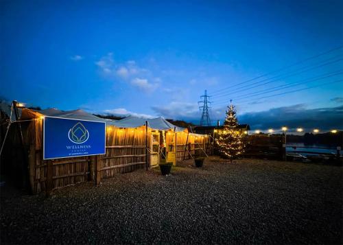 a tent with a christmas tree in front of a fence at St Andrews Lakes in Halling