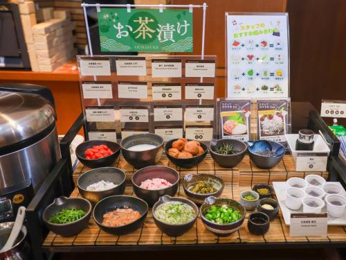 een buffet met kommen eten op tafel bij APA Hotel Obihiro Ekimae in Obihiro