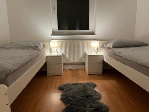 BremerhavenLuxus Apartment im Goetheviertel mit Badewanne, Regendusche WLAN uvm的一只狗躺在地板上,房间带两张床