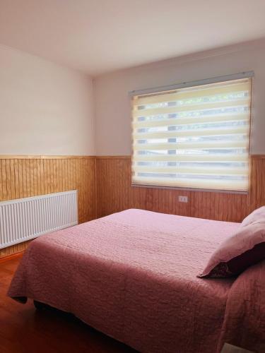 ein Schlafzimmer mit einem großen Bett und einem Fenster in der Unterkunft Cabin for up to 7 people Natales in Puerto Natales