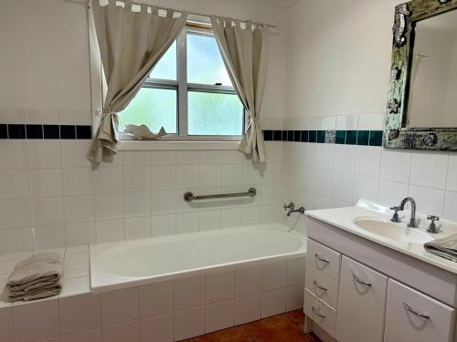 Un baño blanco con bañera y lavabo. en Dunes Aqua at Robe, en Robe