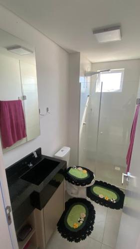 a bathroom with a toilet and a sink and a mirror at Ap sol nascente in Itapema