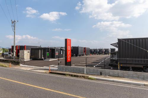 a parking lot with many containers on the side of the road at HOTEL R9 The Yard Shibushi in Nakazono