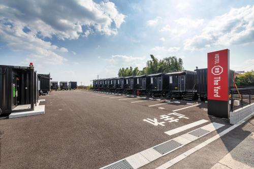 a row of train cars parked in a parking lot at HOTEL R9 The Yard Shibushi in Nakazono