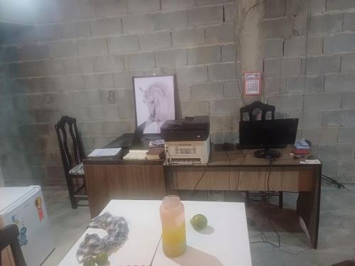 un ufficio con una scrivania con un computer sopra di Rustic Country House a Mogi das Cruzes