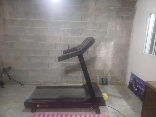 un tapis roulant in una stanza con muro di mattoni di Rustic Country House a Mogi das Cruzes