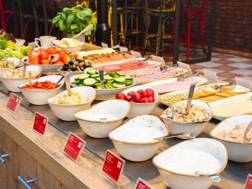 a buffet with many bowls of food on a table at Hotel Ibis Łódź Centrum in Łódź