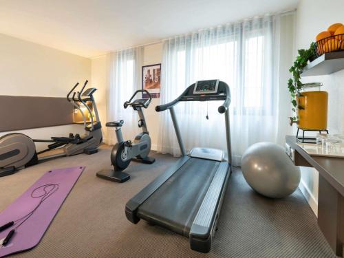 einen Fitnessraum mit Laufband und Trainingsgeräten in der Unterkunft Novotel Suites Paris CDG Airport Villepinte in Roissy-en-France