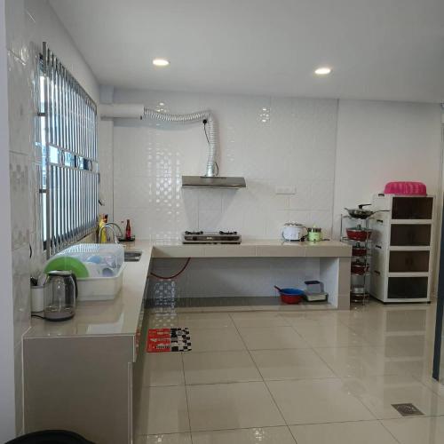 a kitchen with white walls and a counter top at V Love Homestay in Kota Samarahan