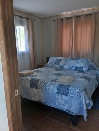 a bedroom with a bed with a blue comforter at Villa Lucita in Manquel