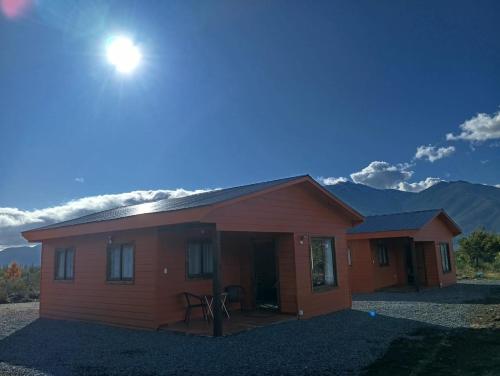 uma pequena casa com o sol no céu em Villa Lucita em Manquel