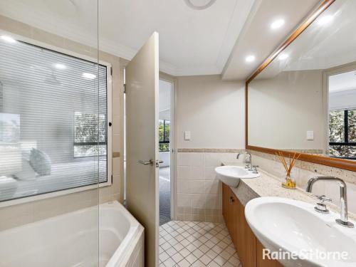 a bathroom with two sinks and a tub and a shower at Villa 7 - The Breakers Resort in Yamba