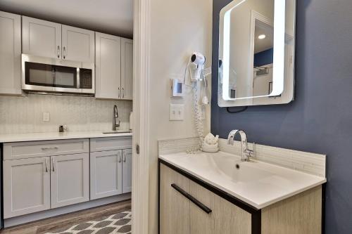 a kitchen with a sink and a mirror at Killington Center Renovated Studio with Kitchenette on Bus Route and Discounted Ski Rentals in The Woods