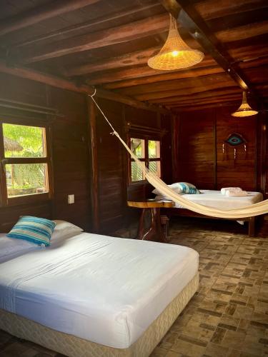 a bedroom with a hammock and a bed in a room at Cabañas Bacali in Bacalar