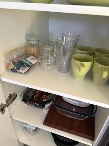 a shelf with some cups and other items on it at Big Tiny Medlow in Medlow Bath