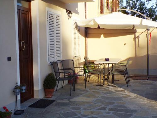 a patio with an umbrella and a table and chairs at Ca'Rino in Bene Vagienna