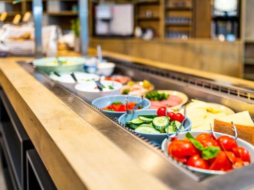uma linha de buffet com muitos pratos de comida em em ibis Hotel Hamburg St. Pauli Messe em Hamburgo