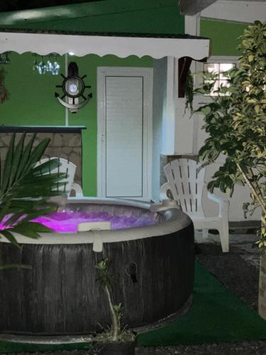ein Haus mit einer Badewanne im Garten in der Unterkunft Tilys lodge in Capesterre-Belle-Eau