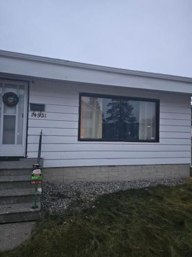 ein weißes Haus mit einem Fenster und einer Veranda in der Unterkunft P&N Suites - Queen Room- DUBAI in Edmonton