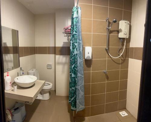 a bathroom with a shower with a sink and a toilet at Ombak Palace Bayou Lagoon Free 2 Waterpark in Melaka