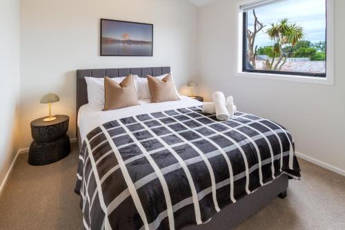 a bedroom with a black and white bed with a window at Modern Family-Friendly Home Near St Albans Park in Christchurch