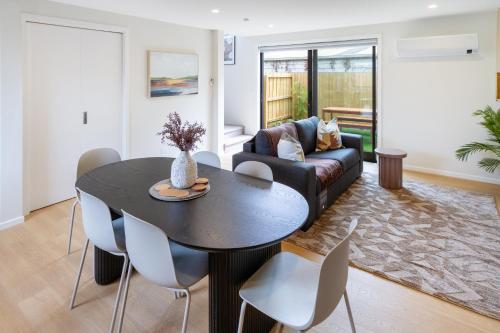 a living room with a table and chairs at Modern Family-Friendly Home Near St Albans Park in Christchurch