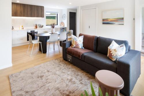 a living room with a couch and a table at Modern Family-Friendly Home Near St Albans Park in Christchurch
