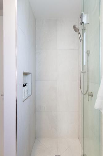 a shower with a glass door in a bathroom at Modern Family-Friendly Home Near St Albans Park in Christchurch